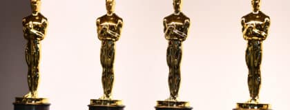 A view of four Oscars statues lined up in a row