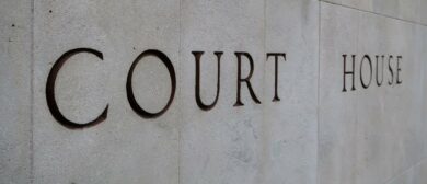 The words 'Court House' etched into a concrete wall, as seen from an angle.