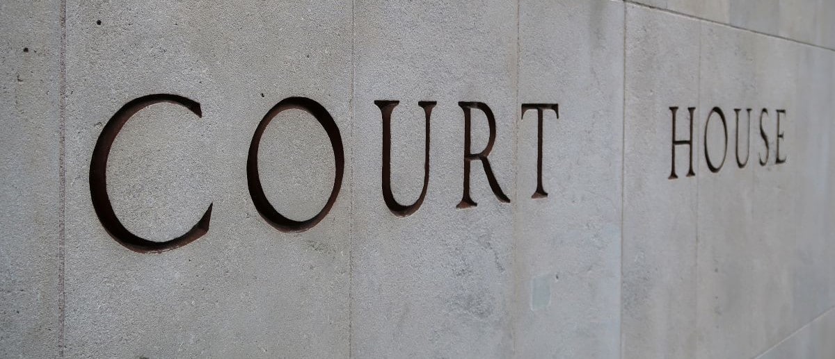 The words 'Court House' etched into a concrete wall, as seen from an angle.