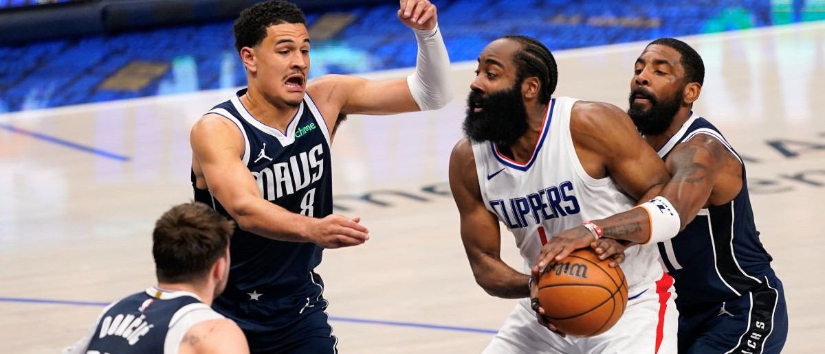 James Harden #1 of the Los Angeles Clippers is defended by Kyrie Irving #11, Josh Green #8 and Luka Doncic #77 of the Dallas Mavericks during the first half of game three of the Western Conference First Round Playoffs at American Airlines Center on April 26, 2024 in Dallas, Texas.