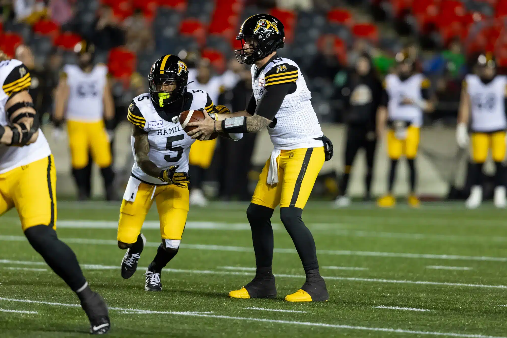 Hamilton Tiger-Cats quarterback Bo Levi Mitchell (19) looks to hand off the ball to running back Greg Bell (5) during Canadian Football League action between the Hamilton Tiger-Cats and Ottawa Redblacks on October 25, 2024, at TD Place Stadium at Lansdowne Park in Ottawa, ON, Canada.