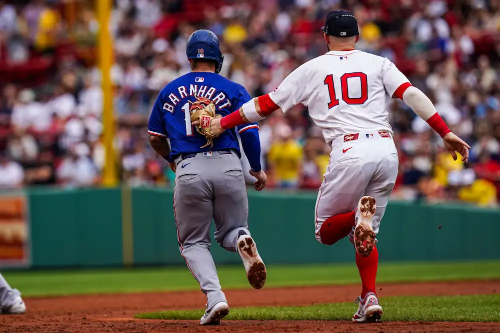 May 8, 2025; Boston, Massachusetts, USA; Texas Rangers catcher Tucker Barnhart (18) tagged out by Boston Red Sox shortstop Trevor Story (10) in the third inning at Fenway Park.