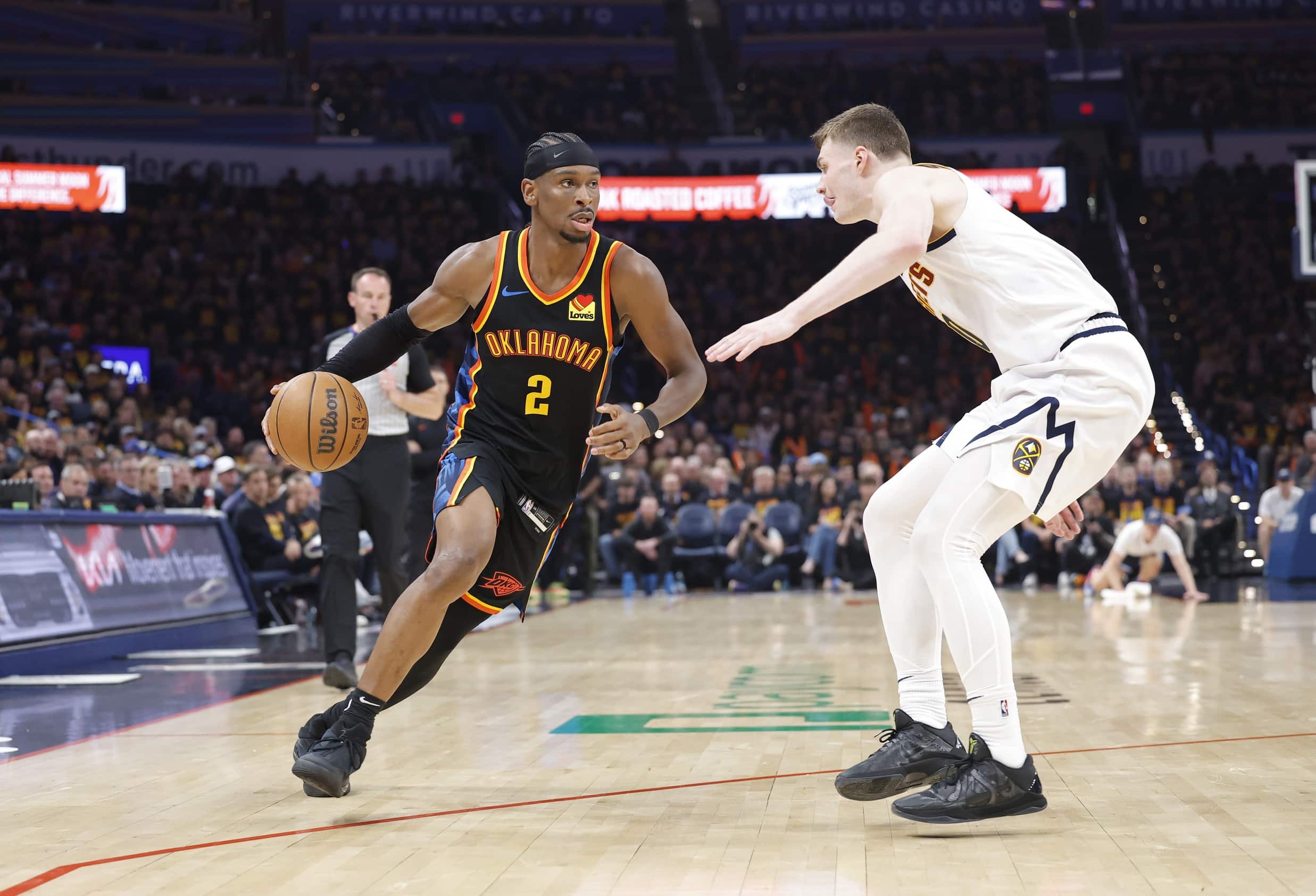 May 5, 2025; Oklahoma City, Oklahoma, USA; Oklahoma City Thunder guard Shai Gilgeous-Alexander (2) drives around Denver Nuggets guard Christian Braun (0) during the second half in game one of the second round for the 2025 NBA Playoffs at Paycom Center. Mandatory Credit: Alonzo Adams-Imagn Images