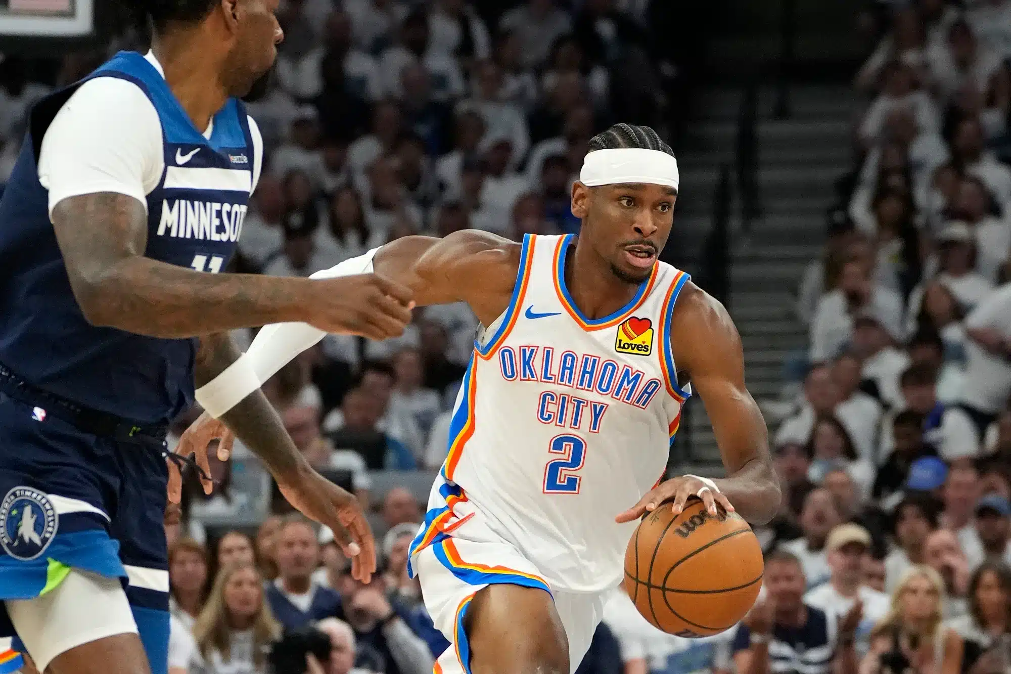May 26, 2025; Minneapolis, Minnesota, USA; Oklahoma City Thunder guard Shai Gilgeous-Alexander (2) dribbles the ball past Minnesota Timberwolves center Naz Reid (11) in the first half during game four of the western conference finals for the 2025 NBA Playoffs at Target Center.