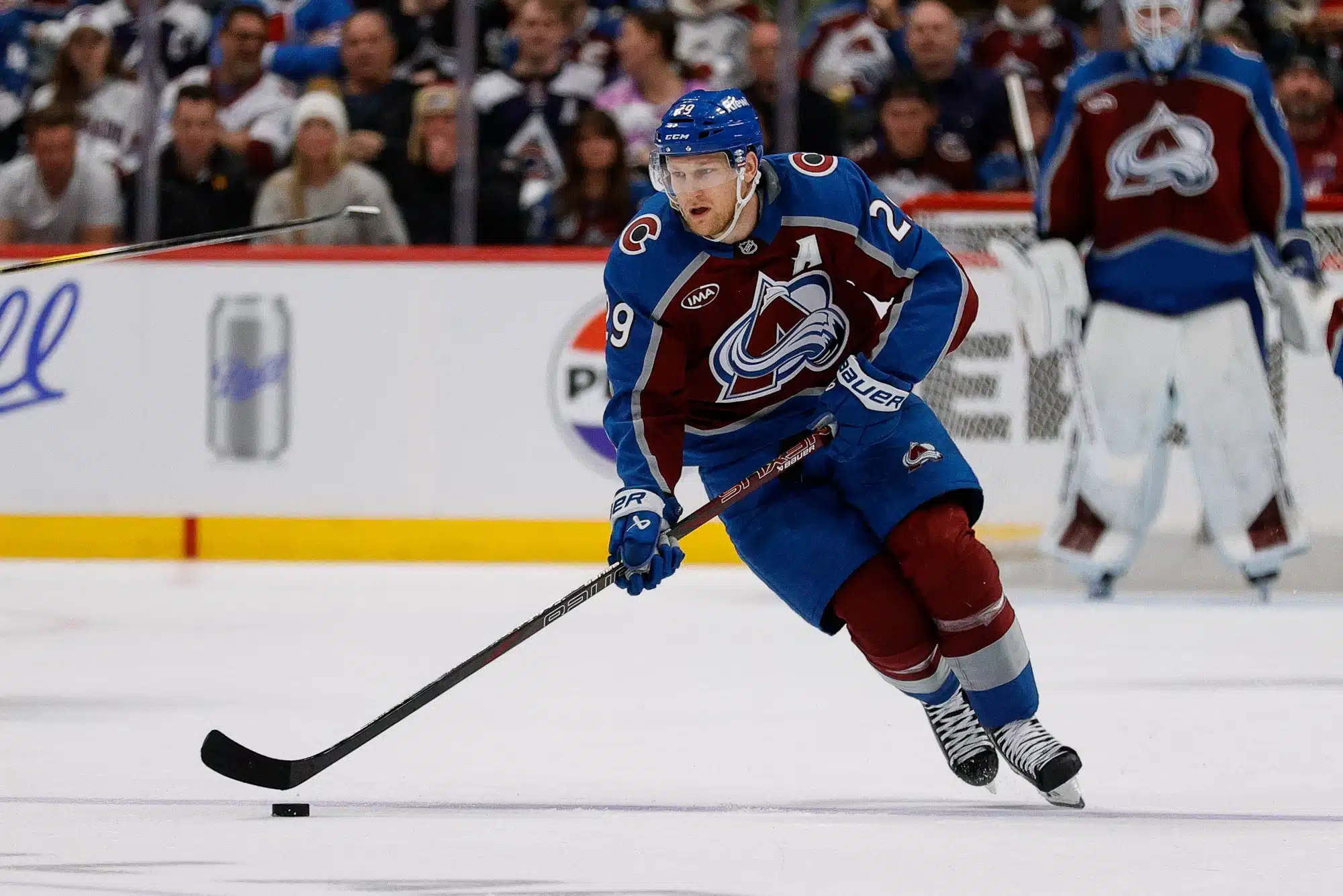 Apr 23, 2025; Denver, Colorado, USA; Colorado Avalanche center Nathan MacKinnon (29) controls the puck in the second period against the Dallas Stars in game three of the first round of the 2025 Stanley Cup Playoffs at Ball Arena.