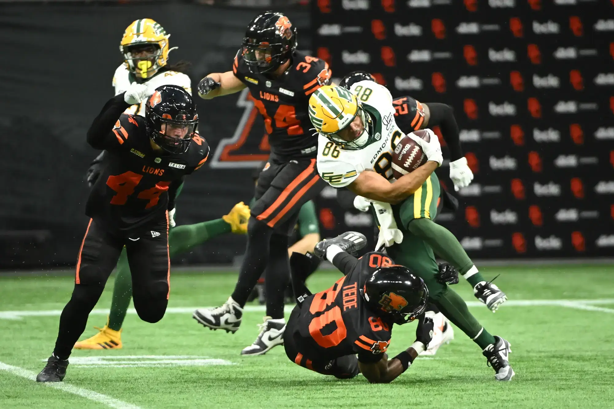 Jun 7, 2025; Vancouver, British Columbia, Canada; BC Lions wide reciever Exechiel Tieide (80) tackles Edmonton Elks wide receiver Arkell Smith (86) during the second half at BC Place Stadium.