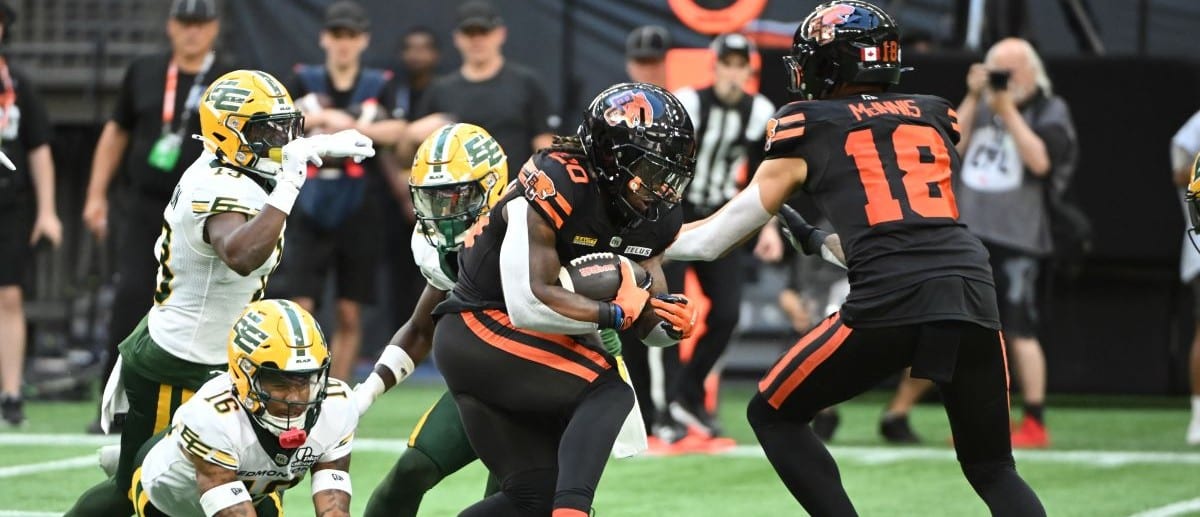 BC Lions running back James Butler (20) runs the ball defended by Edmonton Elks defensive back Devodric Bynum (16) during the first half at BC Place Stadium