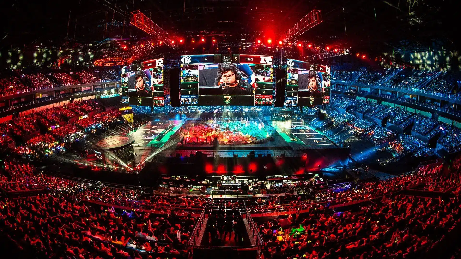 A view of a stadium hosting an esports tournament with giant screens and a full crowd.