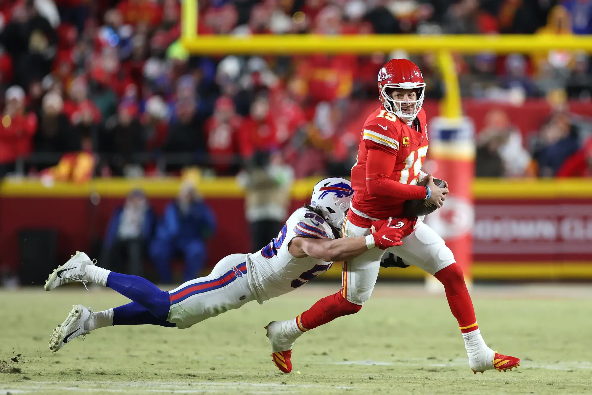 Patrick Mahomes of the Kansas City Chiefs tries to excape a sack by a Buffalo Bills player during an NFL game in 2024.
