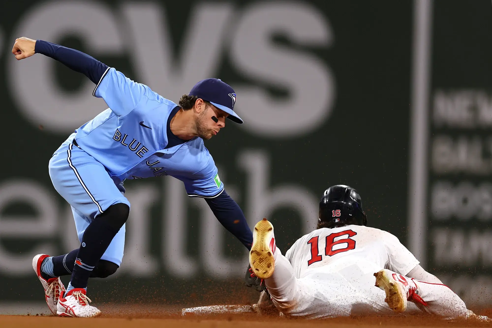 Toronto Blue Jays second baseman tagging a sliding Boston Red Sox player.