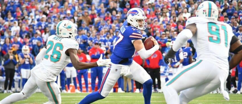 Buffalo Bills quarterback Josh Allen (17) runs between Miami Dolphins safety Marcus Maye (26) and linebacker Emmanuel Ogbah (91) in the fourth quarter at Highmark Stadium.