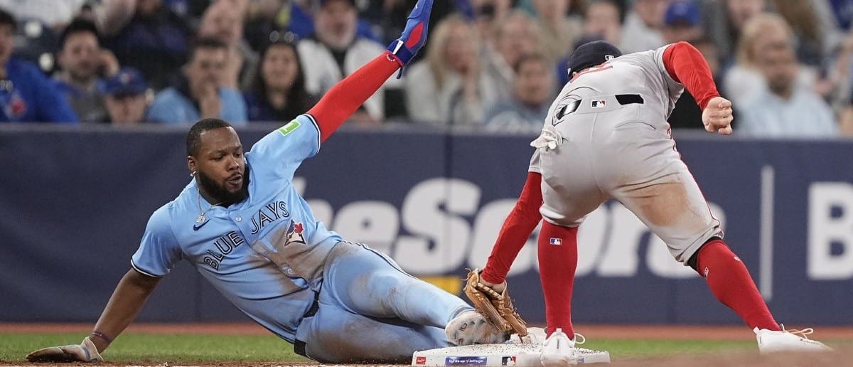 Toronto Blue Jays first baseman Vladimir Guerrero (27) slides in safe to third base against Boston Red Sox third baseman Alex Bregman (2) during the tenth inning at Rogers Centre