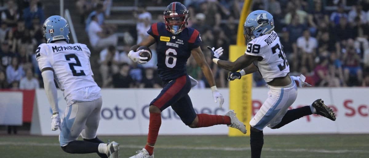 Montreal Alouettes wide receiver Tyson Philpot (6) runs with the ball and Toronto Argonauts defensive back Tarvarus McFadden (2) gives pursuit with teammate linebacker Donald Rutledge (38) during the first half at Percival-Molson stadium