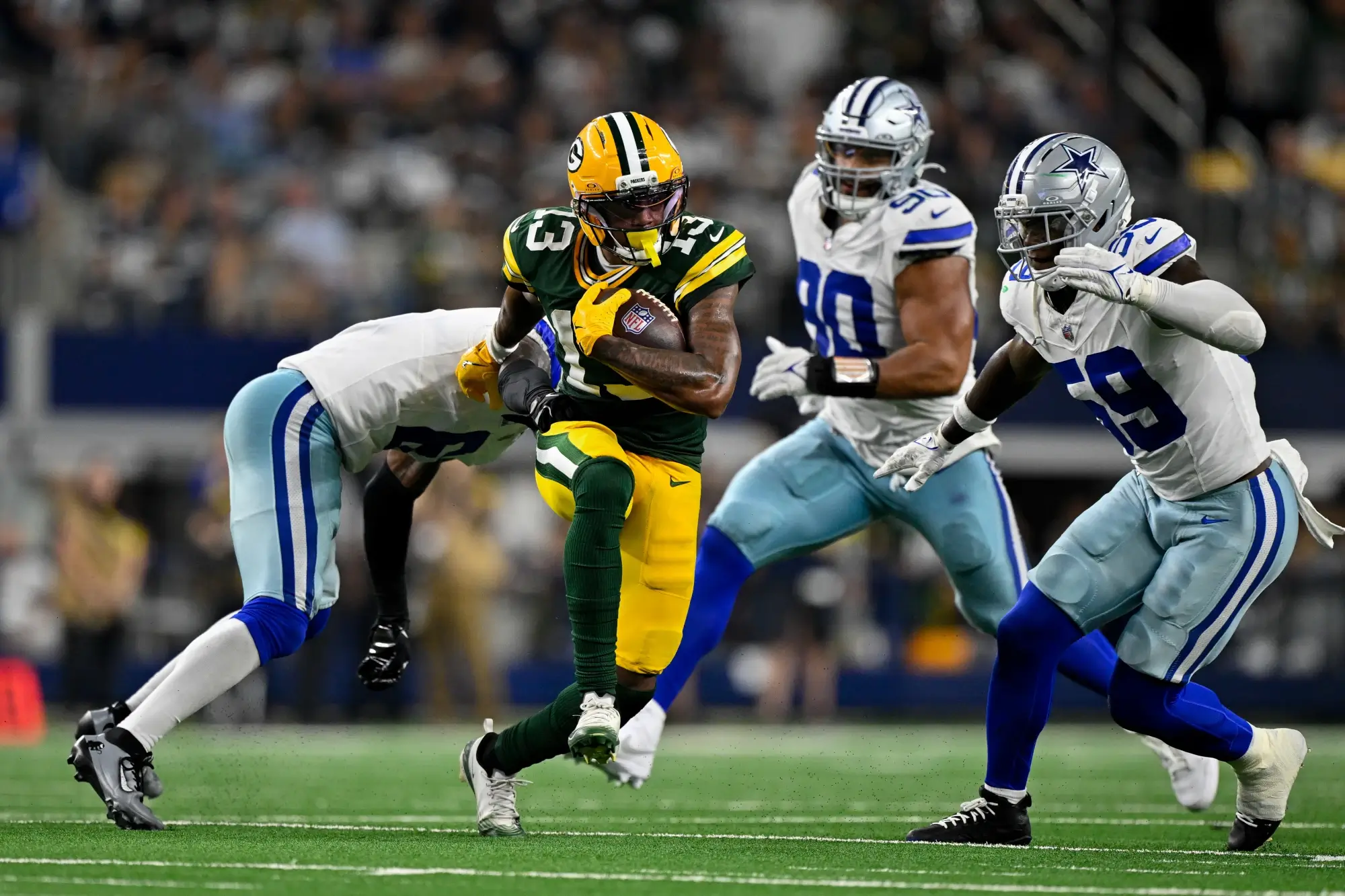 Sep 28, 2025; Arlington, Texas, USA; Dallas Cowboys safety Donovan Wilson (6) attempts to tackle Green Bay Packers wide receiver Dontayvion Wicks (13) during the game between the Dallas Cowboys and the Green Bay Packers at AT&T Stadium.