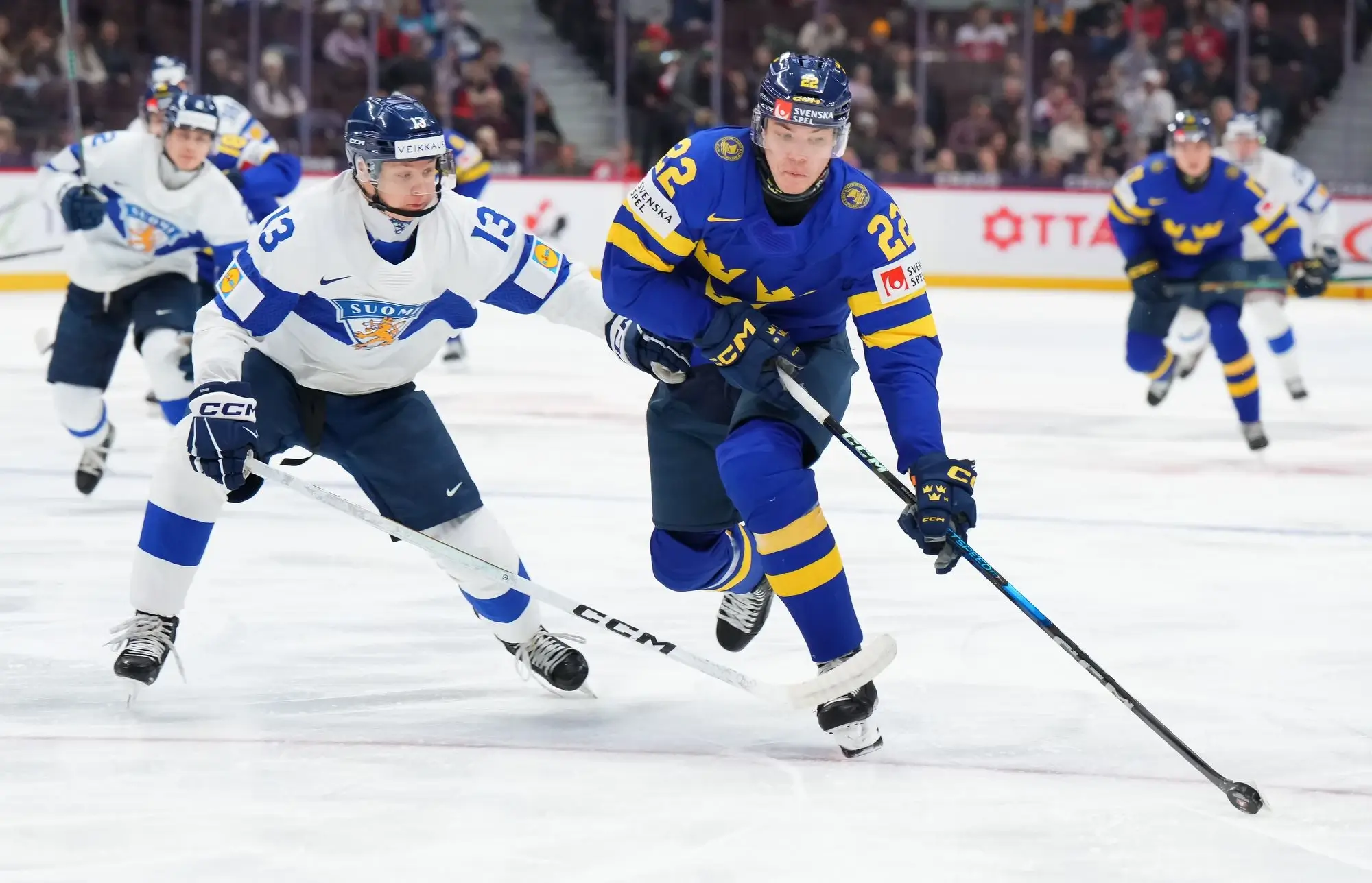 Skaters from Swden and Finland battle for the puck in the semifinal game of the World Juniors in 2025.