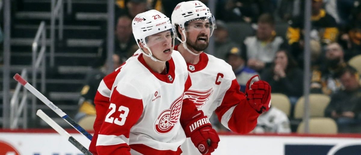 Detroit Red Wings left wing Lucas Raymond (23) and center Dylan Larkin (71) celebrate after Raymond scored a goal to complete a hat-trick against the Pittsburgh Penguins during the third period at PPG Paints Arena. Pittsburgh won 6-5 in overtime