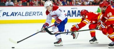 Montreal Canadiens right wing Cole Caufield (13) controls the puck against Calgary Flames defenseman Joel Hanley (44) and defenseman MacKenzie Weegar (52) during the third period at Scotiabank Saddledome
