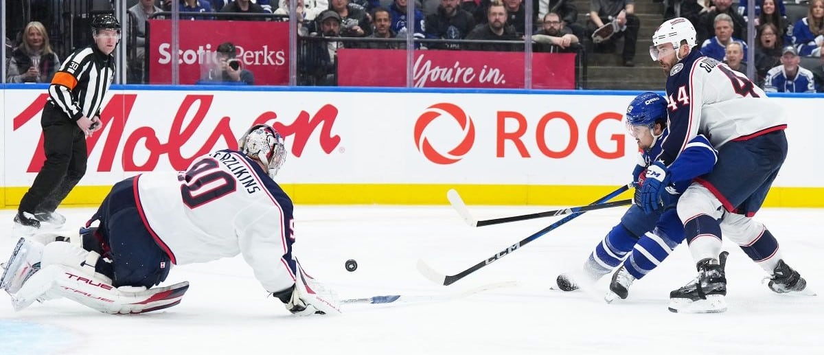 Toronto Maple Leafs left wing Nicholas Robertson (89) battles for the puck with Columbus Blue Jackets defenseman Erik Gudbranson (44) during the third period at Scotiabank Arena.