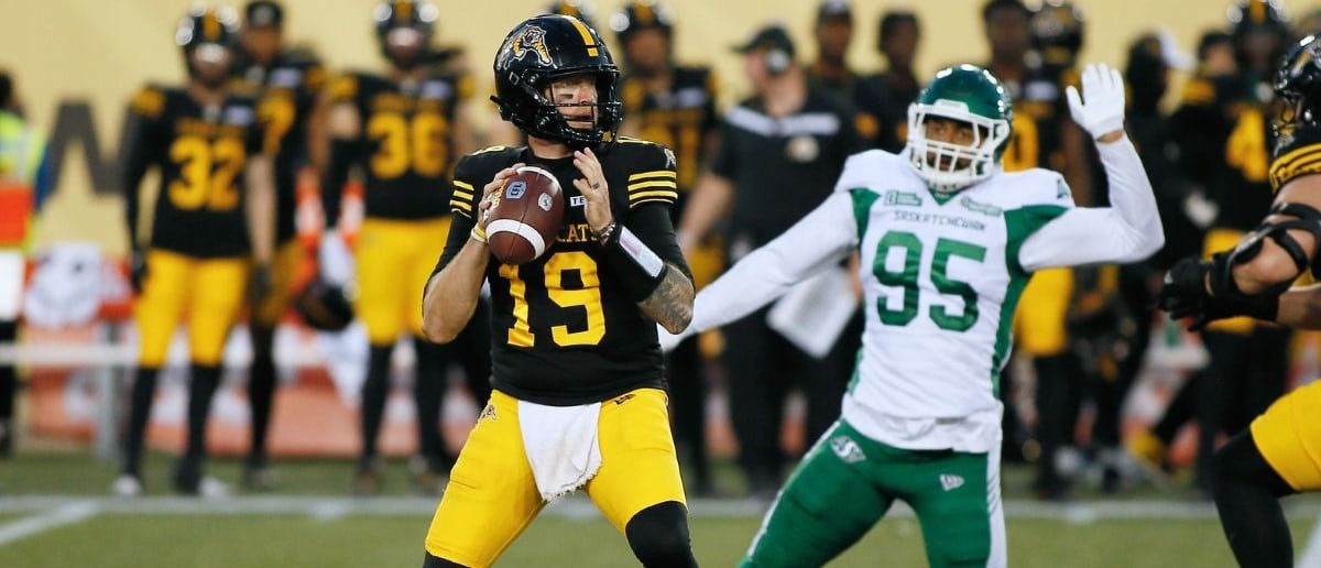 Hamilton Tiger-Cats quarterback Bo Levi Mitchell (19) looks to pass as Saskatchewan Roughriders defensive lineman Habakkuk Baldonado (95) closes in at Hamilton Stadium.
