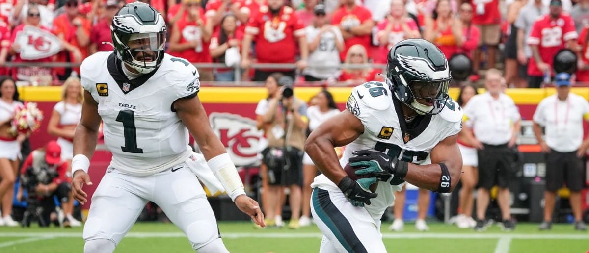 Philadelphia Eagles quarterback Jalen Hurts (1) hands the ball off to running back Saquon Barkley (26) against the Kansas City Chiefs during the second quarter of the game at GEHA Field at Arrowhead Stadium.
