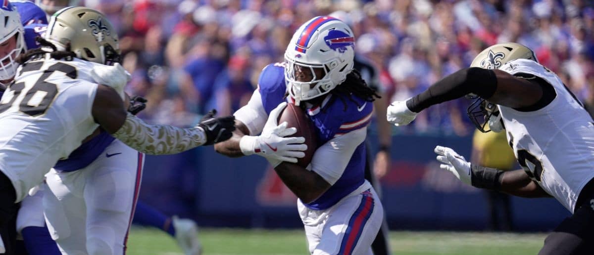 Buffalo Bills running back James Cook avoids the reaching hands of New Orleans Saints outside linebacker Demario Davis during first half action of the Bills home game against the New Orleans Saints in Orchard Park on Sept. 28, 2025.
