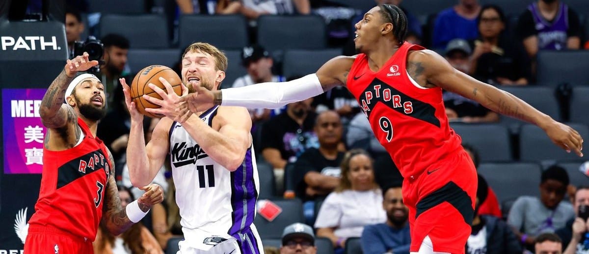Sacramento Kings forward/center Domantas Sabonis (11) fights for a rebound against Toronto Raptors forward Brandon Ingram (3) and forward/guard RJ Barrett (9) during the third quarter at Golden 1 Center.