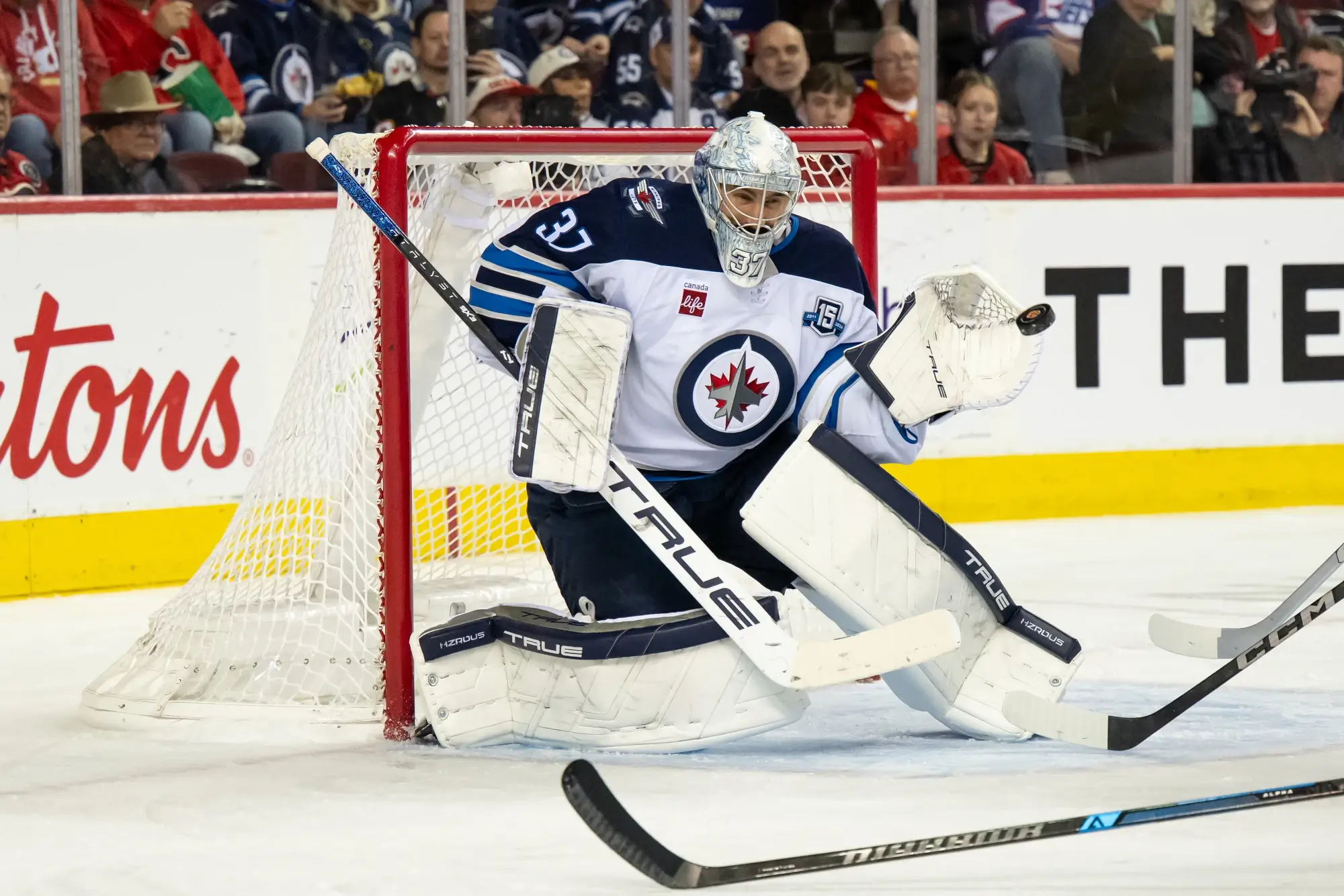 Oct 20, 2025; Calgary, Alberta, CAN; Winnipeg Jets goaltender Connor Hellebuyck (37) keeps his eye on the puck during the second period of a game against the Calgary Flames at Scotiabank Saddledome. 