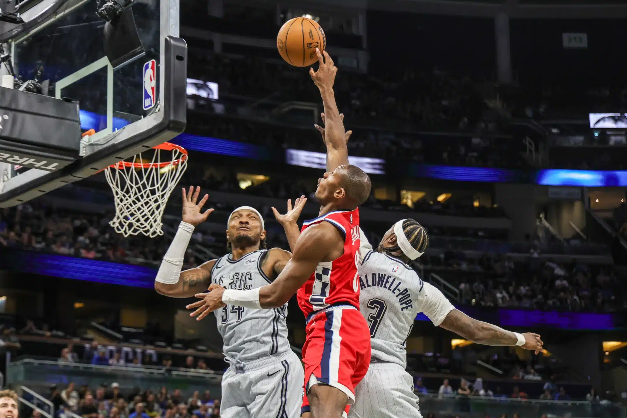 Mar 31, 2025; Orlando, Florida, USA; LA Clippers guard Kris Dunn (8), Orlando Magic center Wendell Carter Jr. (34) and Orlando Magic guard Kentavious Caldwell-Pope (3) jump for a rebound during the second half at Kia Center. 