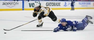 Toronto Maple Leafs forward Auston Matthews (34) dives to tip a puck into the empty net against Boston Bruins forward David Pastrnak (88) during the third period at Scotiabank Arena.