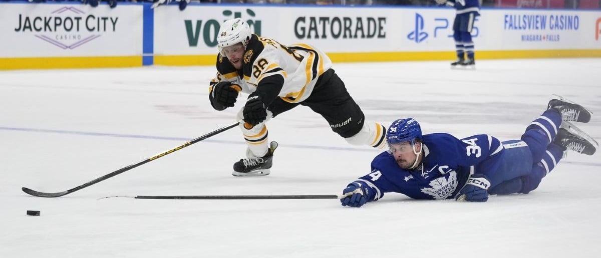 Toronto Maple Leafs forward Auston Matthews (34) dives to tip a puck into the empty net against Boston Bruins forward David Pastrnak (88) during the third period at Scotiabank Arena.