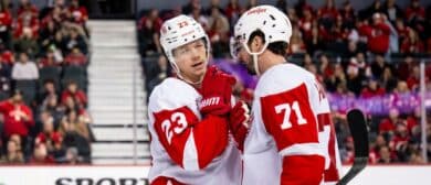 Detroit Red Wings left wing Lucas Raymond (23) and center Dylan Larkin (71) talk strategy before a face-off against the Calgary Flames during the third period at Scotiabank Saddledome