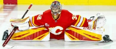 Calgary Flames goaltender Dustin Wolf (32) stretches during the warmup period against the Winnipeg Jets at Scotiabank Saddledome