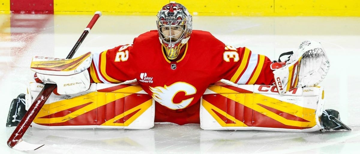 Calgary Flames goaltender Dustin Wolf (32) stretches during the warmup period against the Winnipeg Jets at Scotiabank Saddledome