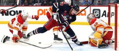 Calgary Flames defenseman Jake Bean (24) and Winnipeg Jets center Jonathan Toews (19) try for a rebound in front of Flames goaltender Dustin Wolf (32) in the second period at Canada Life Centre.