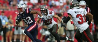 New England Patriots running back Treveyon Henderson (32) runs for a gain past Tampa Bay Buccaneers cornerback Zyon McCollum (27) and safety Antoine Winfield Jr. (31) during the third quarter at Raymond James Stadium.