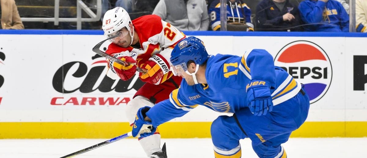 Calgary Flames right wing Matt Coronato (27) shoots as St. Louis Blues defenseman Cam Fowler (17) defends during the first period at Enterprise Center.