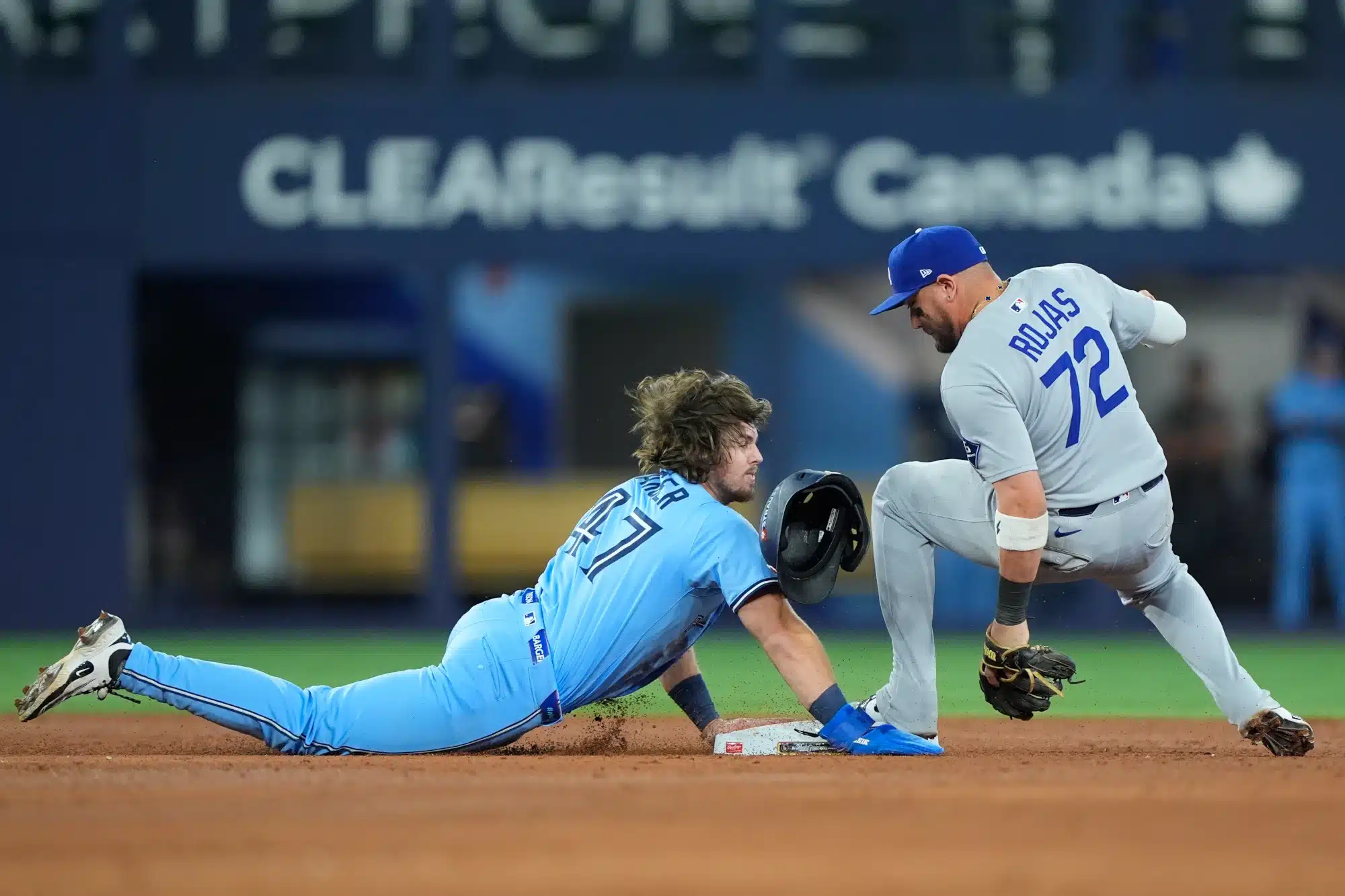 Oct 31, 2025; Toronto, Ontario, CAN; Los Angeles Dodgers second baseman Miguel Rojas (72) makes a double play against Toronto Blue Jays third baseman Addison Barger (47) in the ninth inning during game six of the 2025 MLB World Series at Rogers Centre.