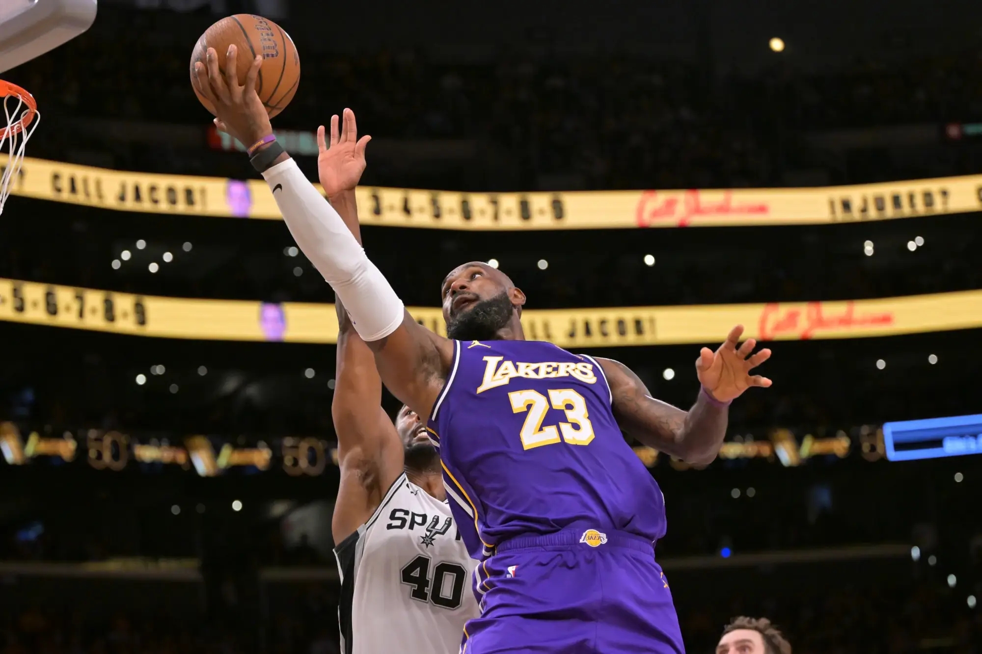 Dec 10, 2025; Los Angeles, California, USA; Los Angeles Lakers forward Lebron James (23) is defended by San Antonio Spurs forward Harrison Barnes (40) as he drives to the basket during the second half at Crypto.com Arena.