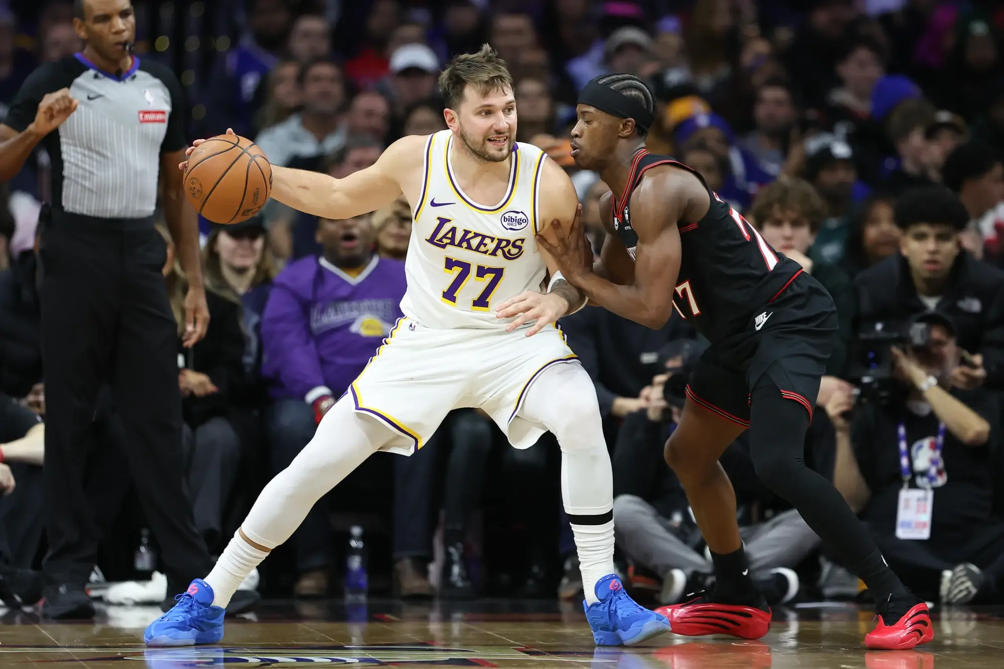 Dec 7, 2025; Philadelphia, Pennsylvania, USA; Los Angeles Lakers guard Luka Doncic (77) controls the ball against Philadelphia 76ers guard Vj Edgecombe (77) during the third quarter at Xfinity Mobile Arena. 