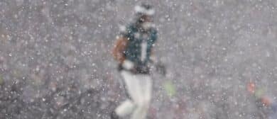 Philadelphia Eagles quarterback Jalen Hurts (1) is obscured by snow before a play against the Los Angeles Rams in a 2025 NFC divisional round game at Lincoln Financial Field.