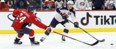 Columbus Blue Jackets defenseman Zach Werenski (8) passes the puck as Washington Capitals center Connor McMichael (24) defends during the second period at Capital One Arena.