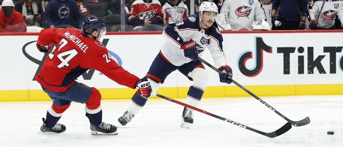 Columbus Blue Jackets defenseman Zach Werenski (8) passes the puck as Washington Capitals center Connor McMichael (24) defends during the second period at Capital One Arena.