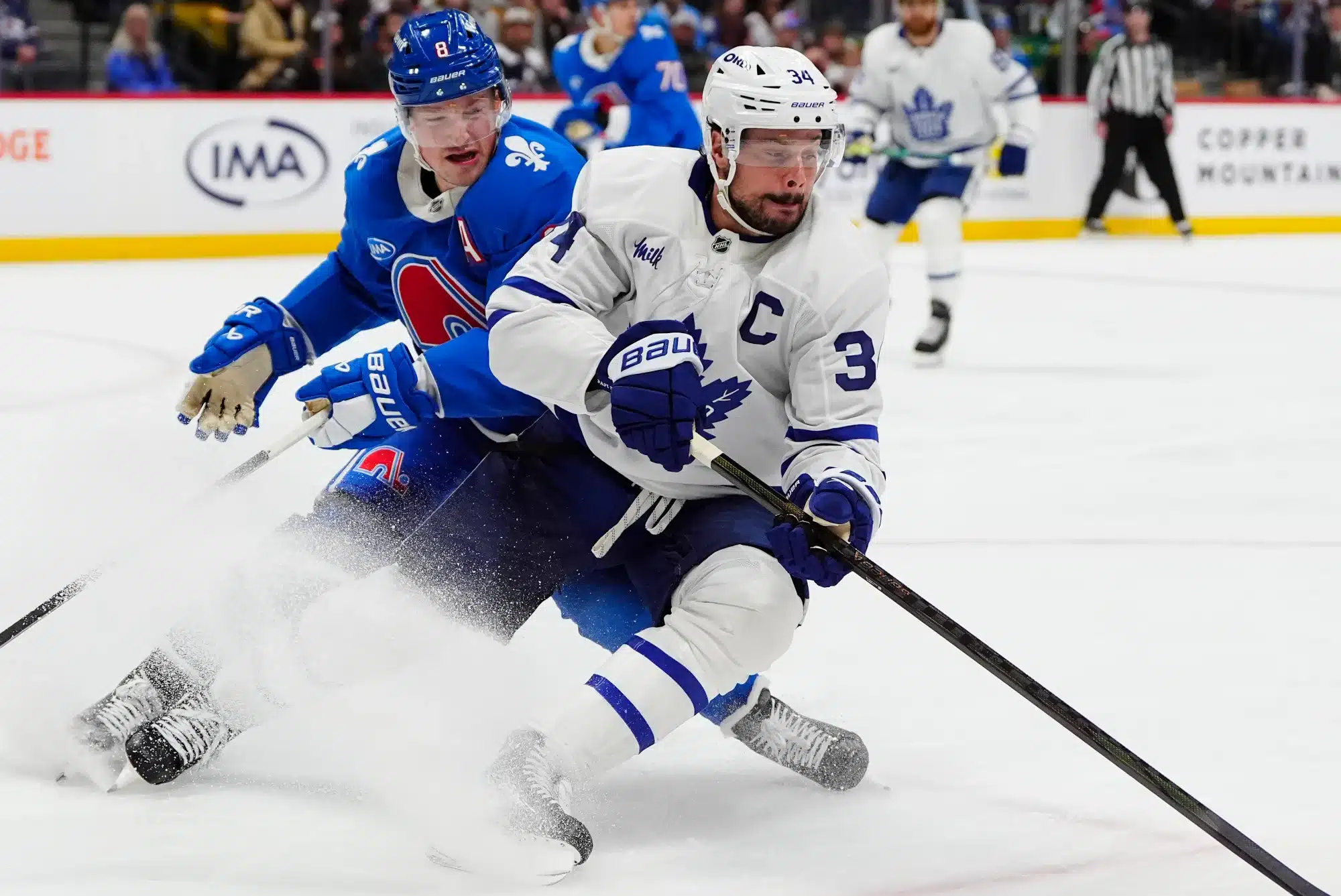 Jan 12, 2026; Denver, Colorado, USA; Toronto Maple Leafs center Auston Matthews (34) and Colorado Avalanche defenseman Cale Makar (8) battle for the puck in the third period at Ball Arena.