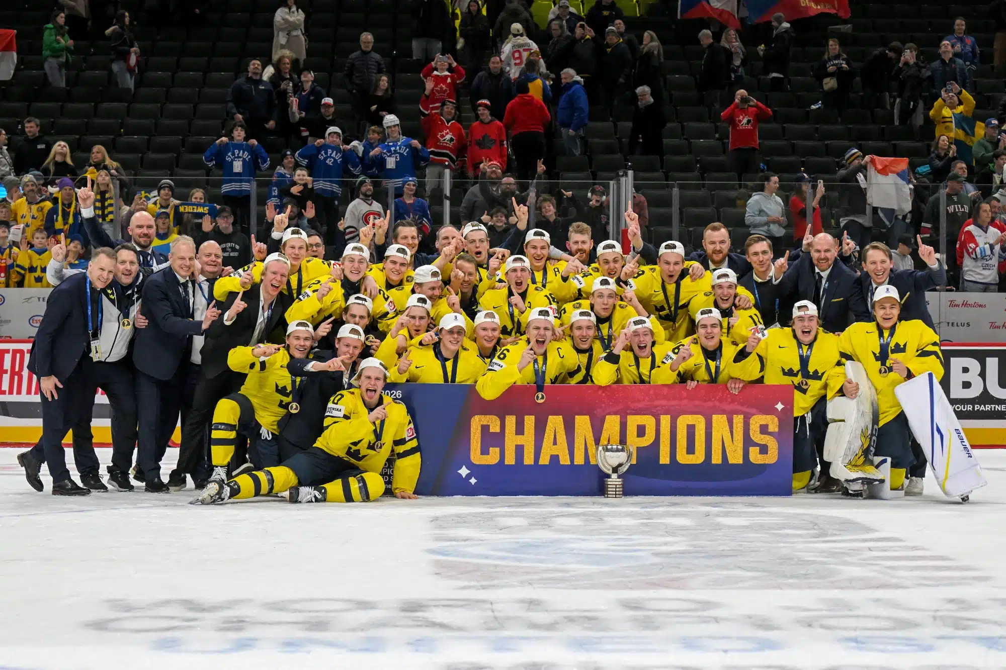 Team Sweden celebrates winning the 2026 World Juniors Championship by taking a team picture on ice.
