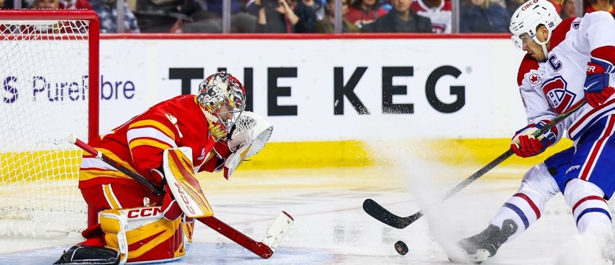 Calgary Flames goaltender Dustin Wolf (32) makes a save against Montreal Canadiens center Nick Suzuki (14) during the third period at Scotiabank Saddledome.