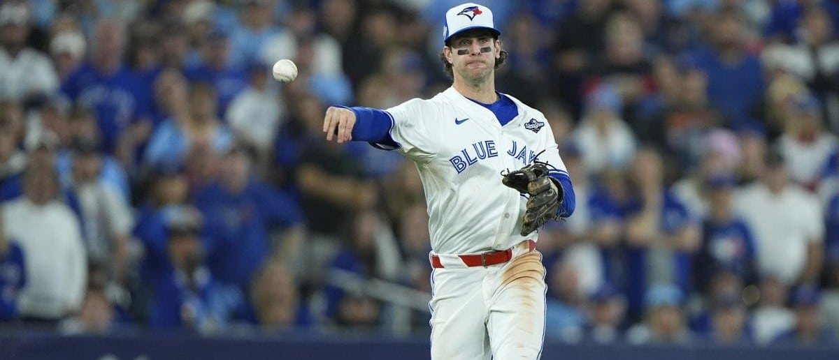Toronto Blue Jays third baseman Ernie Clement (22) throws to first for an out against Los Angeles Dodgers second baseman Miguel Rojas (72) in the eleventh inning during game seven of the 2025 MLB World Series at Rogers Centre