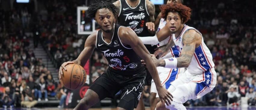 Toronto Raptors guard Immanuel Quickley (5) dribbles around Philadelphia 76ers forward Kelly Oubre Jr. (9) during the second half at Scotiabank Arena