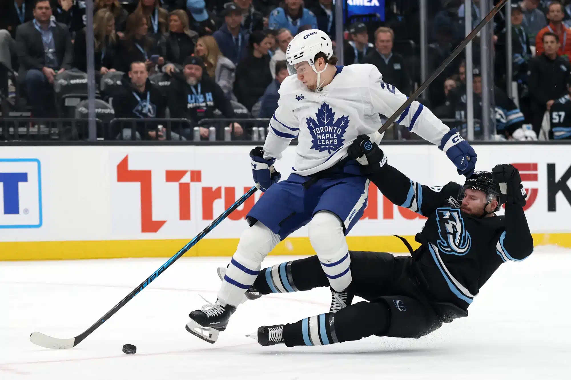 Jan 13, 2026; Salt Lake City, Utah, USA; Toronto Maple Leafs left wing Matthew Knies (23) and Utah Mammoth defenseman Ian Cole (28) battle for the puck during the third period at Delta Center.