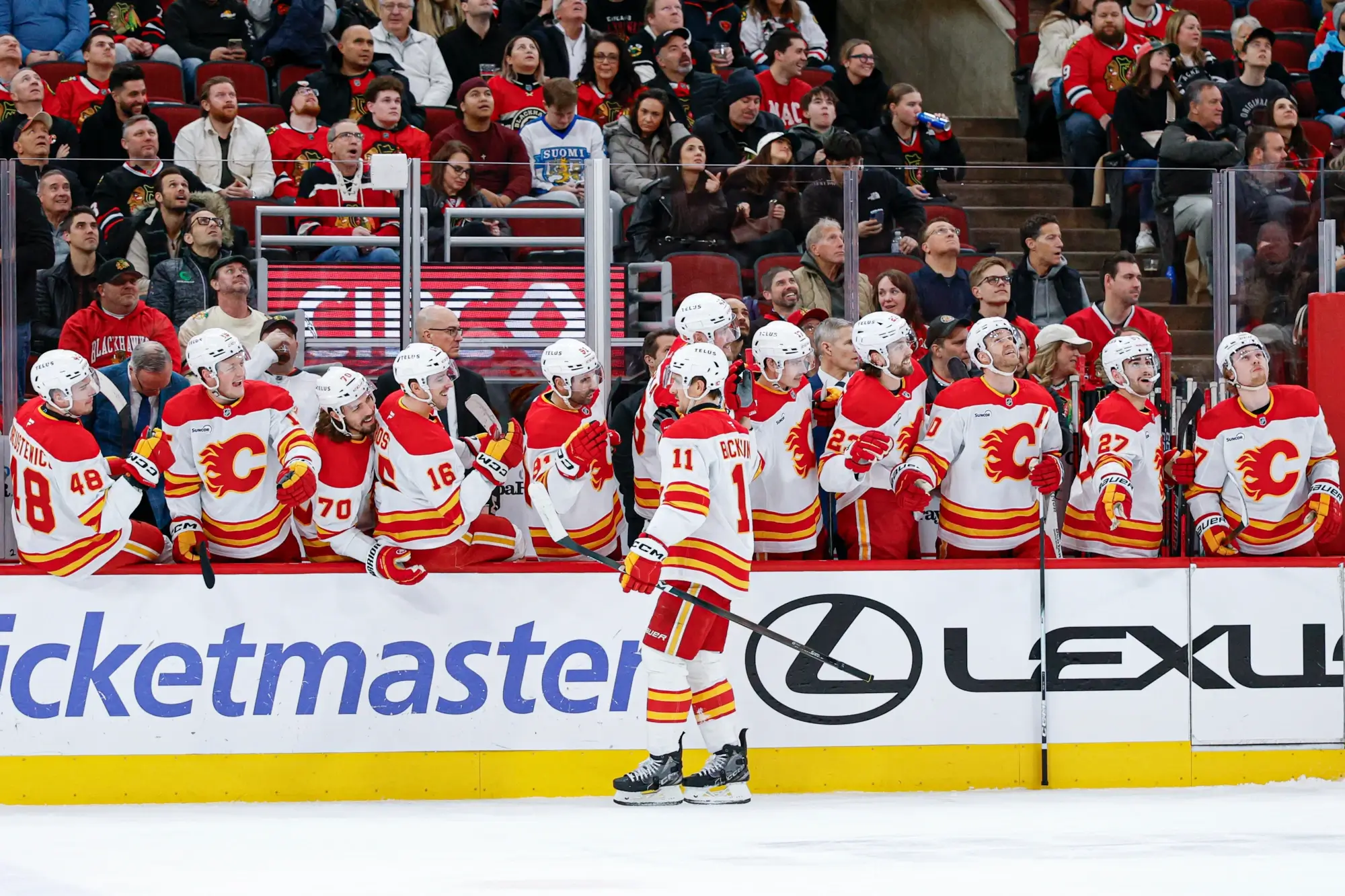 Jan 15, 2026; Chicago, Illinois, USA; Calgary Flames center Mikael Backlund (11) celebrates with teammates after scoring against the Chicago Blackhawks during the first period at United Center. 