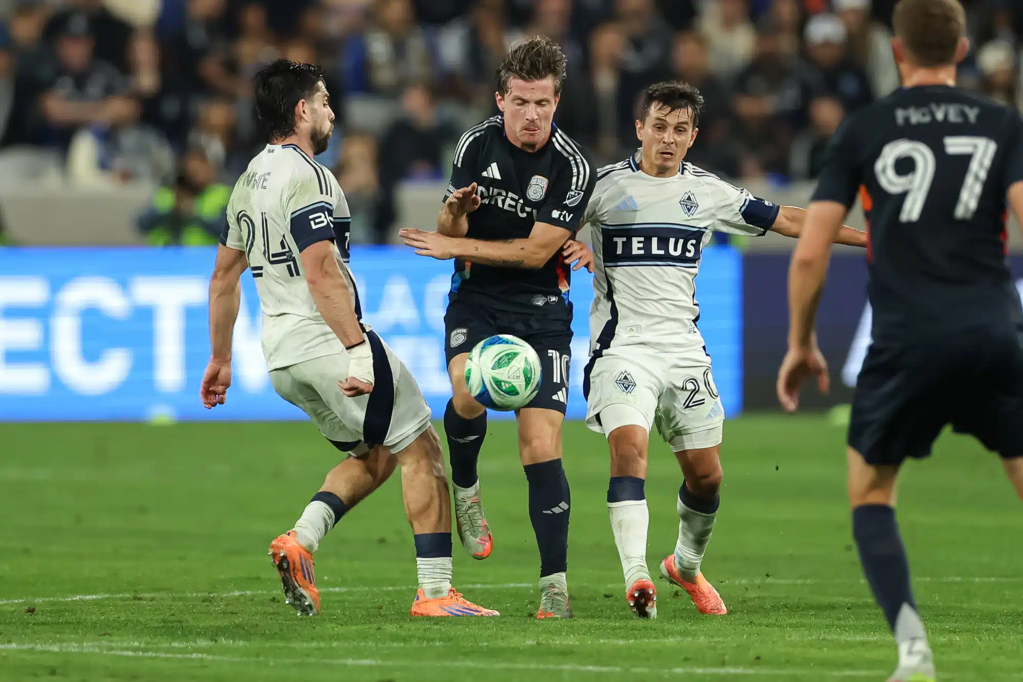 Nov 29, 2025; San Diego, California, USA; San Diego FC midfielder Anders Dreyer (10) competes for control with Vancouver Whitecaps forward Brian White (24) and midfielder Andres Cubas (20) during the first half at Snapdragon Stadium.